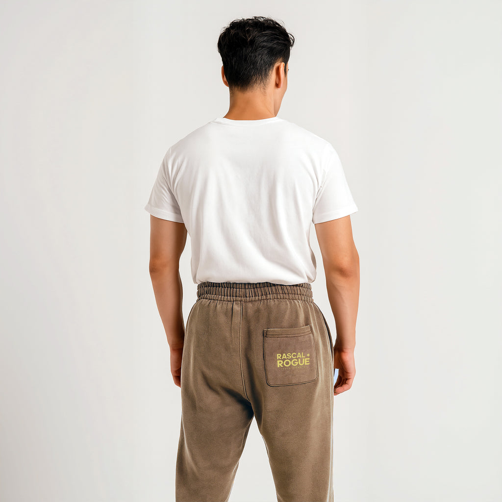 Person wearing brown pants with a brand logo on a plain background